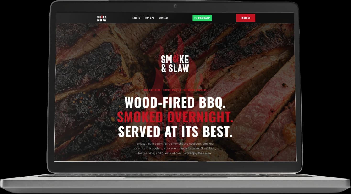 A laptop showing the Smoke & Slaw homepage: close-up sliced brisket filling the screen behind the logo and the line 'Wood-fired BBQ. Smoked overnight. Served at its best.'