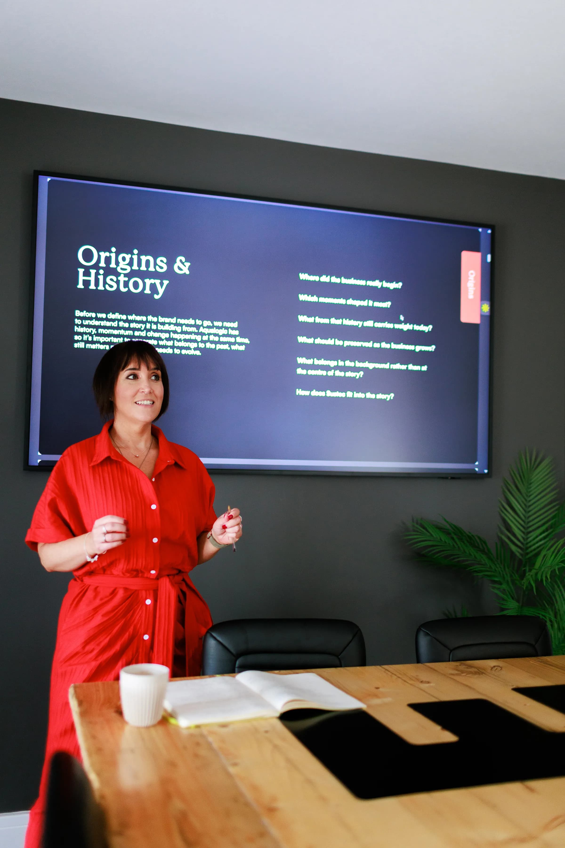 Jess Morgan leading a brand workshop in the Alchemy studio, in front of a slide of questions.