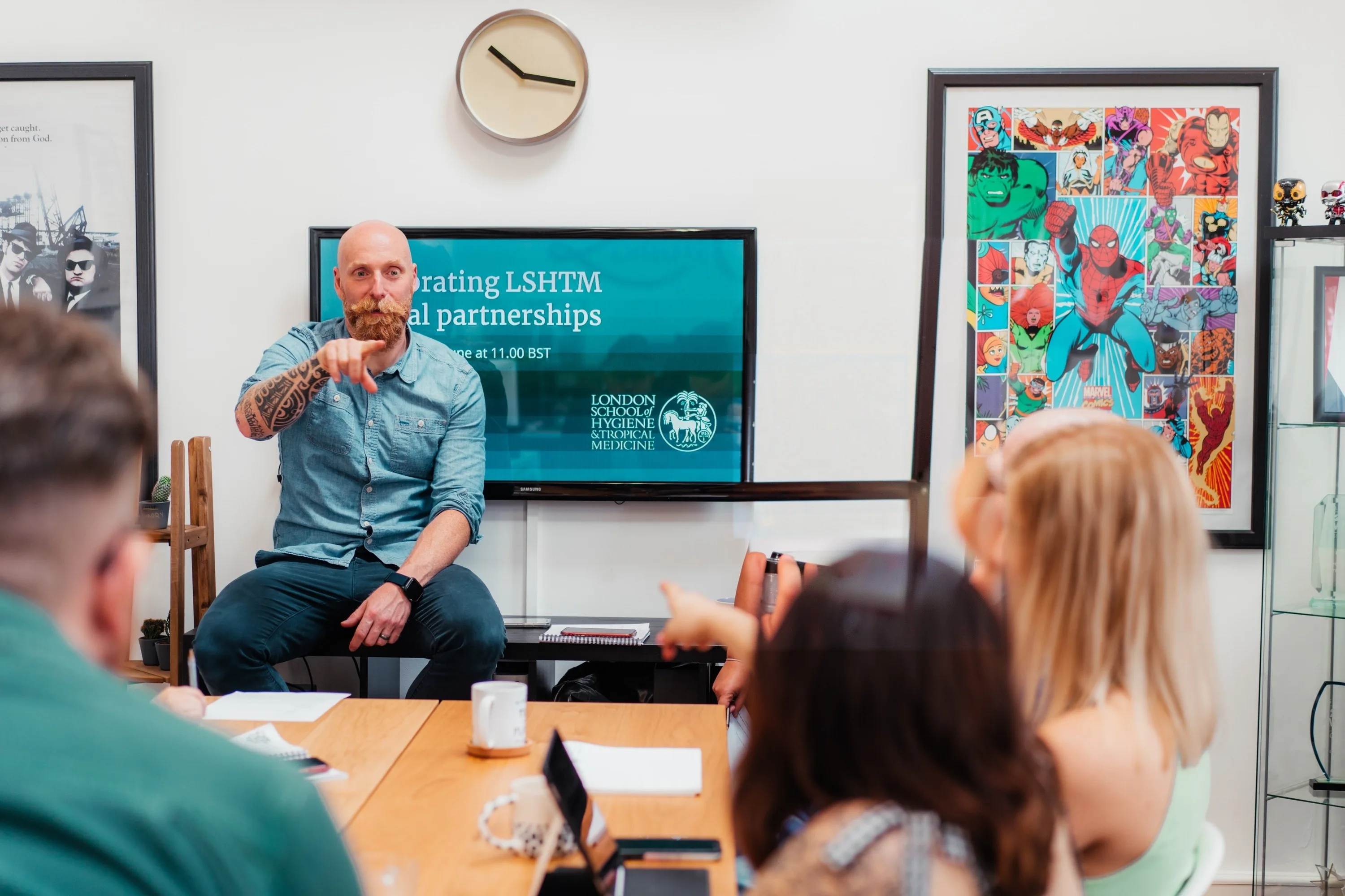 Dave Morgan pointing as he answers a question in a brand workshop, with the room turned towards him.